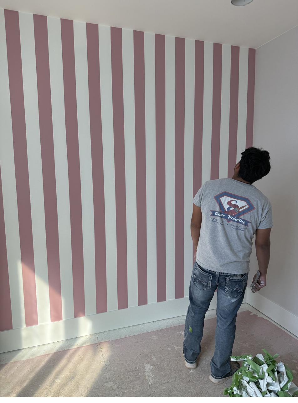 Finished pink and white striped accent wall