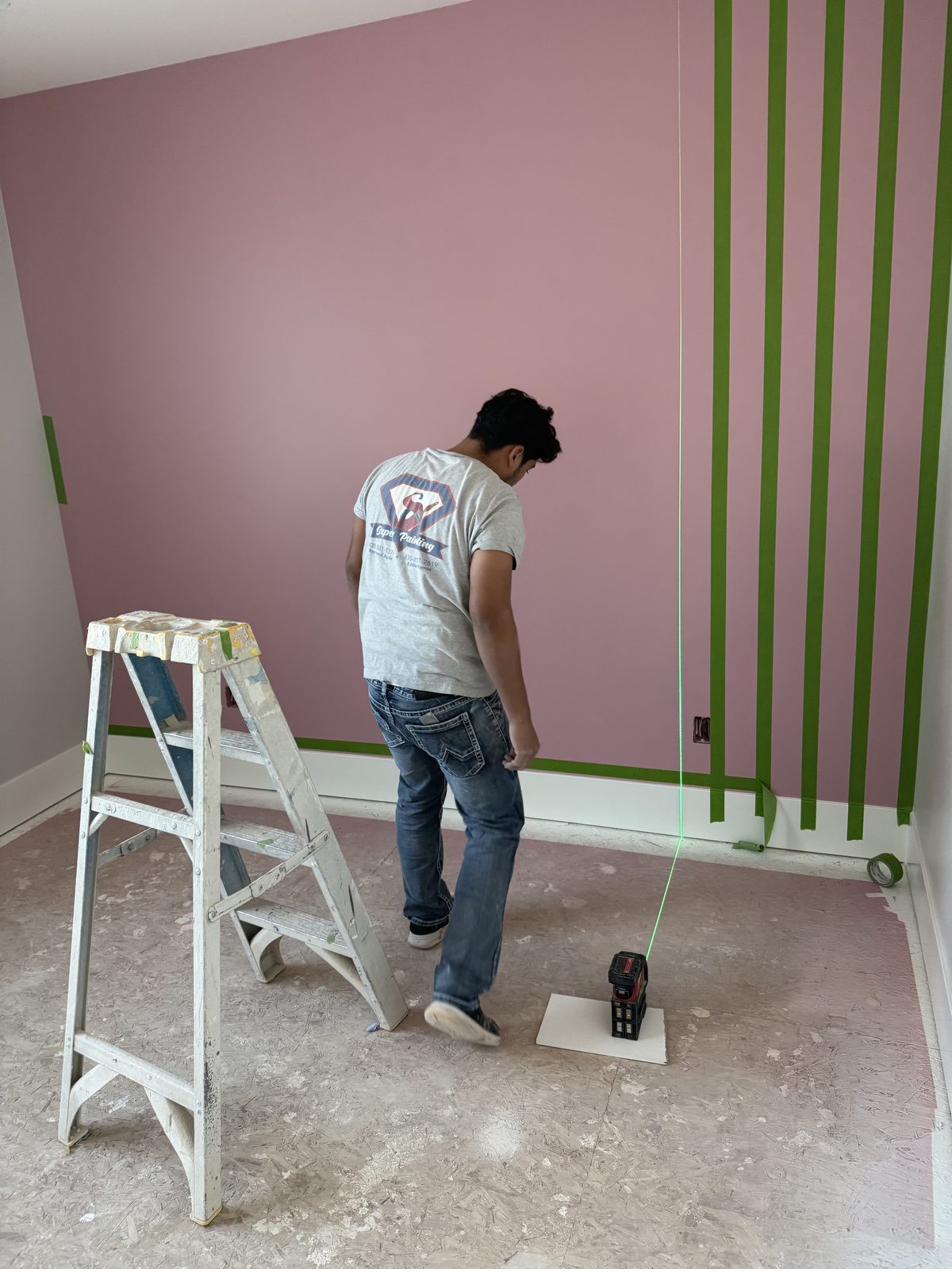 Laser-level layout lines taped on a wall before painting